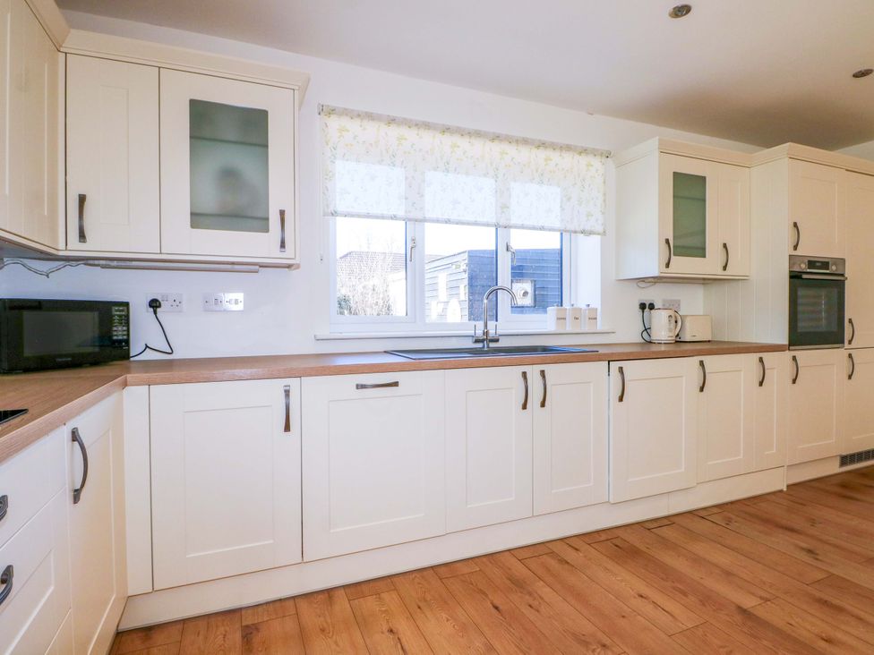 A kitchen with cabinets and appliances at Snowdrop Cottage in Maidstone
