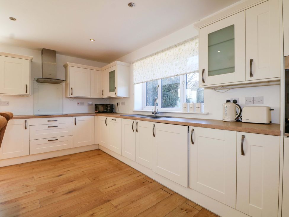 A kitchen with cabinets, a sink, microwave, and toaster at Snowdrop Cottage in Maidstone