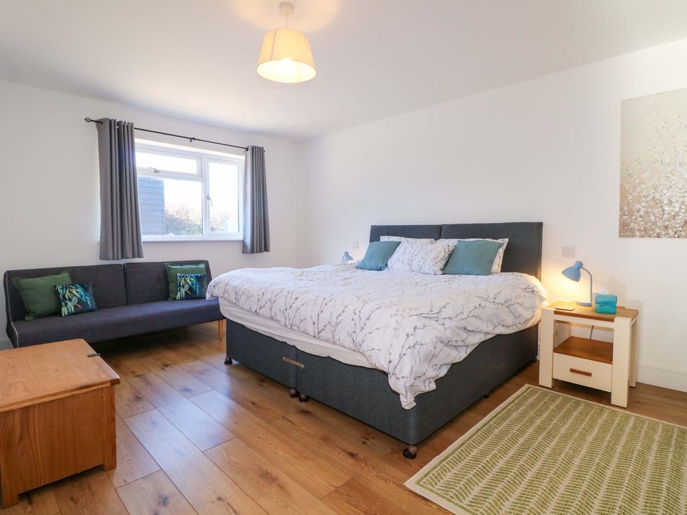 A bedroom with a bed and sofa at Snowdrop Cottage Maidstone