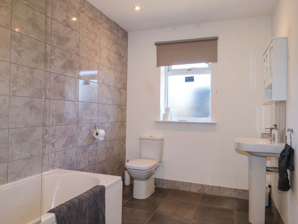 A bathroom with a bathtub, toilet and sink at Snowdrop Cottage in Maidstone