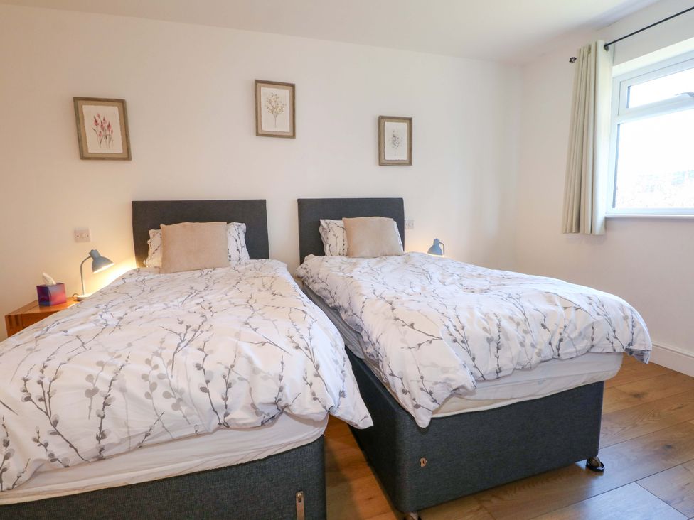 A bedroom with two beds and a window at Snowdrop Cottage in Maidstone
