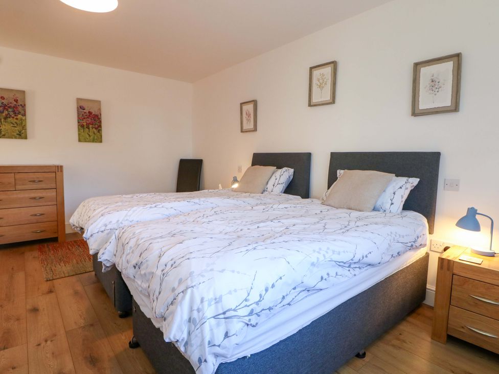 A bedroom with two beds and a chest of drawers at Snowdrop Cottage Maidstone