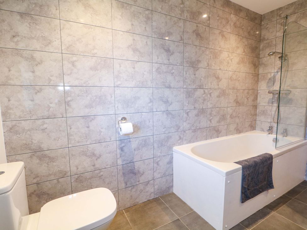 A bathroom with a bathtub and toilet at Snowdrop Cottage in Maidstone