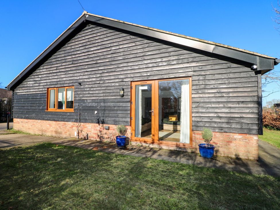 A house with a wooden exterior and a pathway at Snowdrop Cottage in Maidstone