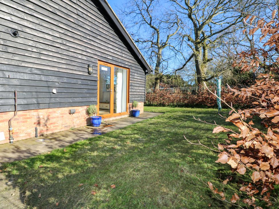 A garden with brick wall and blue flower pots at Snowdrop Cottage Maidstone