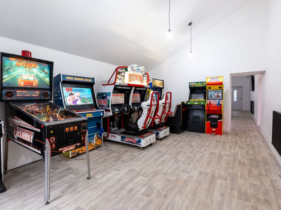 A game room with various arcade machines at Manor Farm in Glastonbury