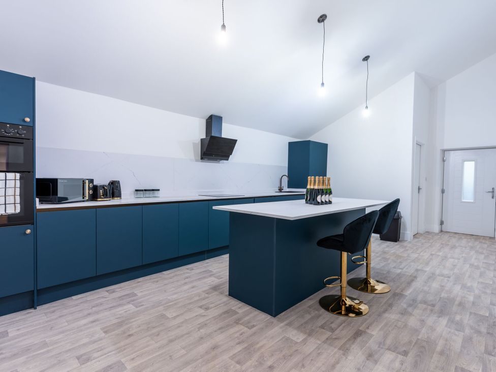 A kitchen with a bar area and appliances at Manor Farm in Glastonbury