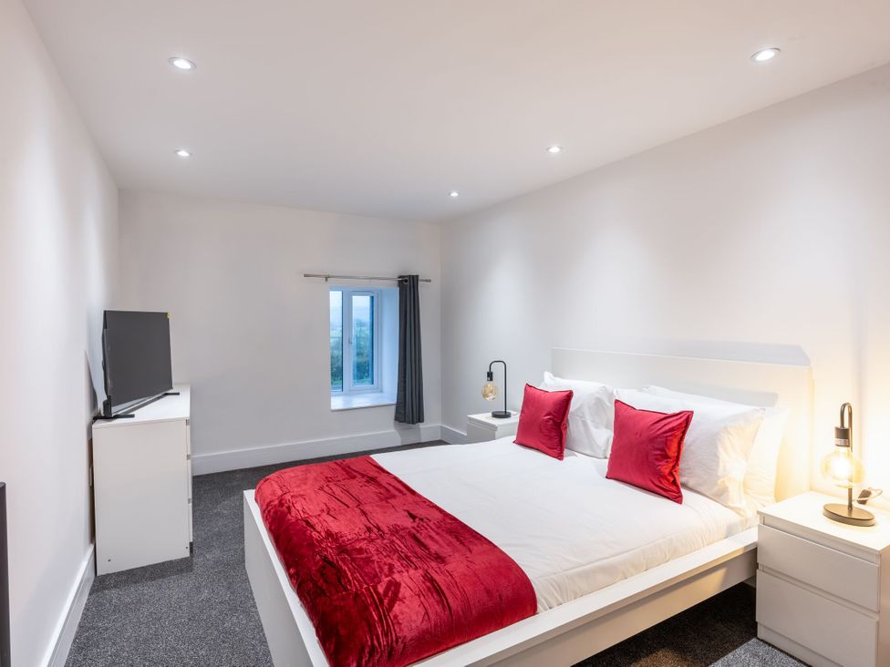 A bedroom with a bed and television at Manor Farm in Glastonbury