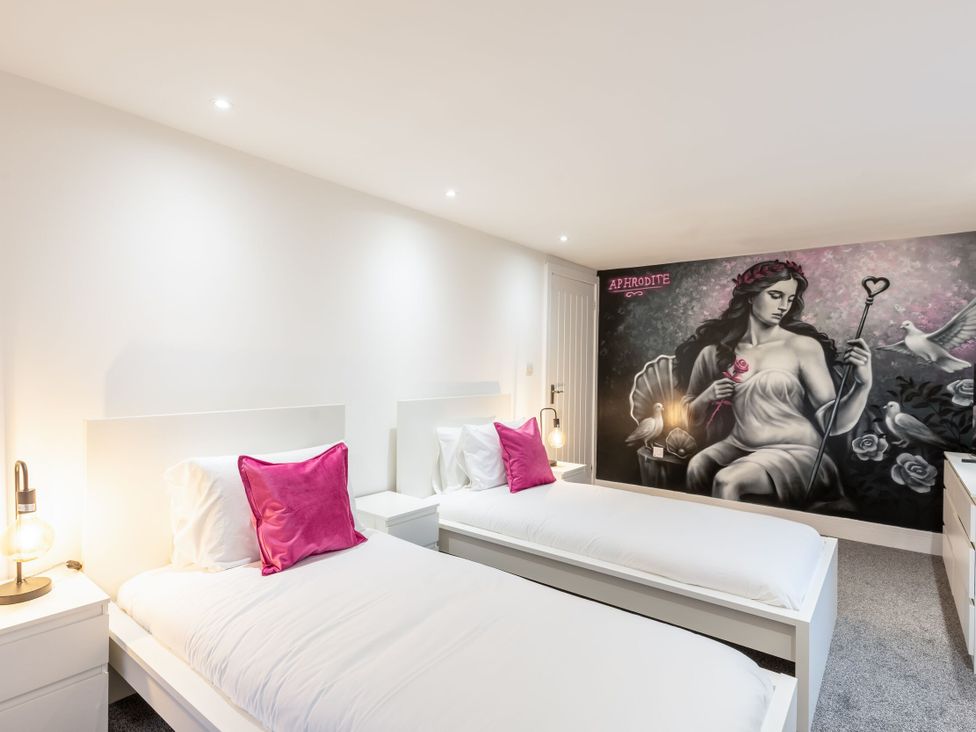 A bedroom with two single beds and a mural at Manor Farm in Glastonbury