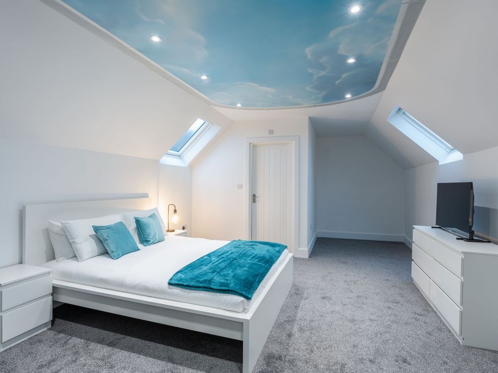 A bedroom with a bed and television at Manor Farm in Glastonbury