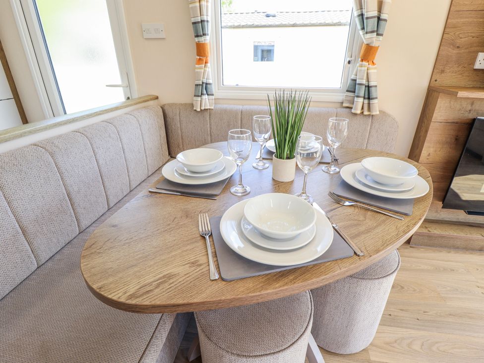 A dining room with a table set for a meal at 39 Larch View with hot tub Tattershall