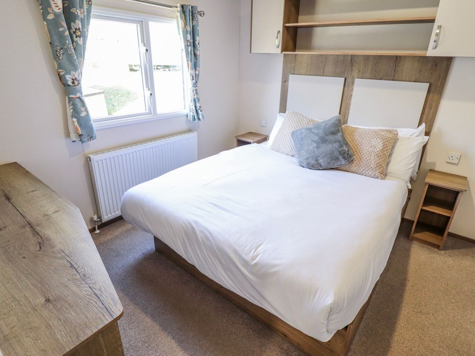 A bedroom with a bed and bedside table at 39 Larch View with hot tub Tattershall