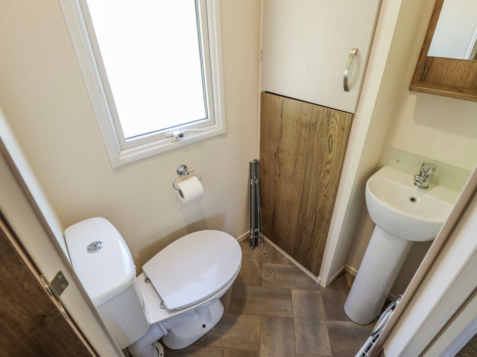 A bathroom with a toilet and sink at 39 Larch View with hot tub Tattershall