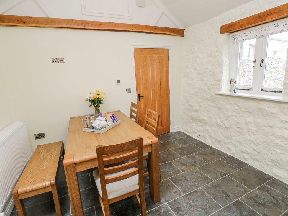 A dining room with a table and chairs at Barley Cottage in Oxwich