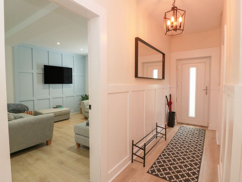 A hallway with a mirror and door at Olea in Portpatrick