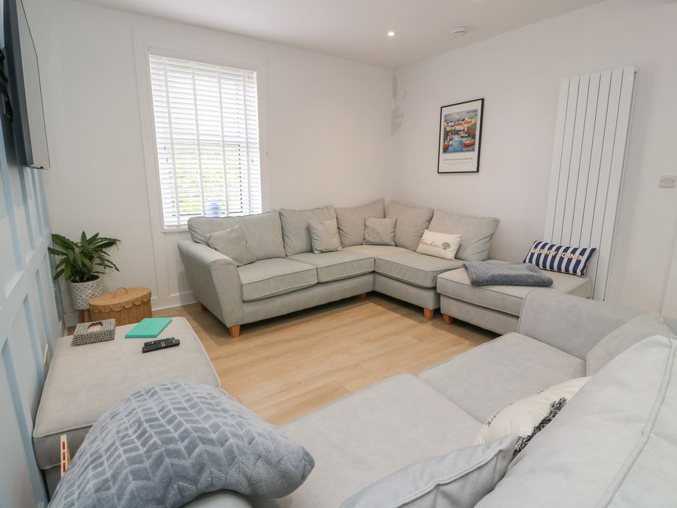 A living room with a grey sofa and a plant at Olea Portpatrick