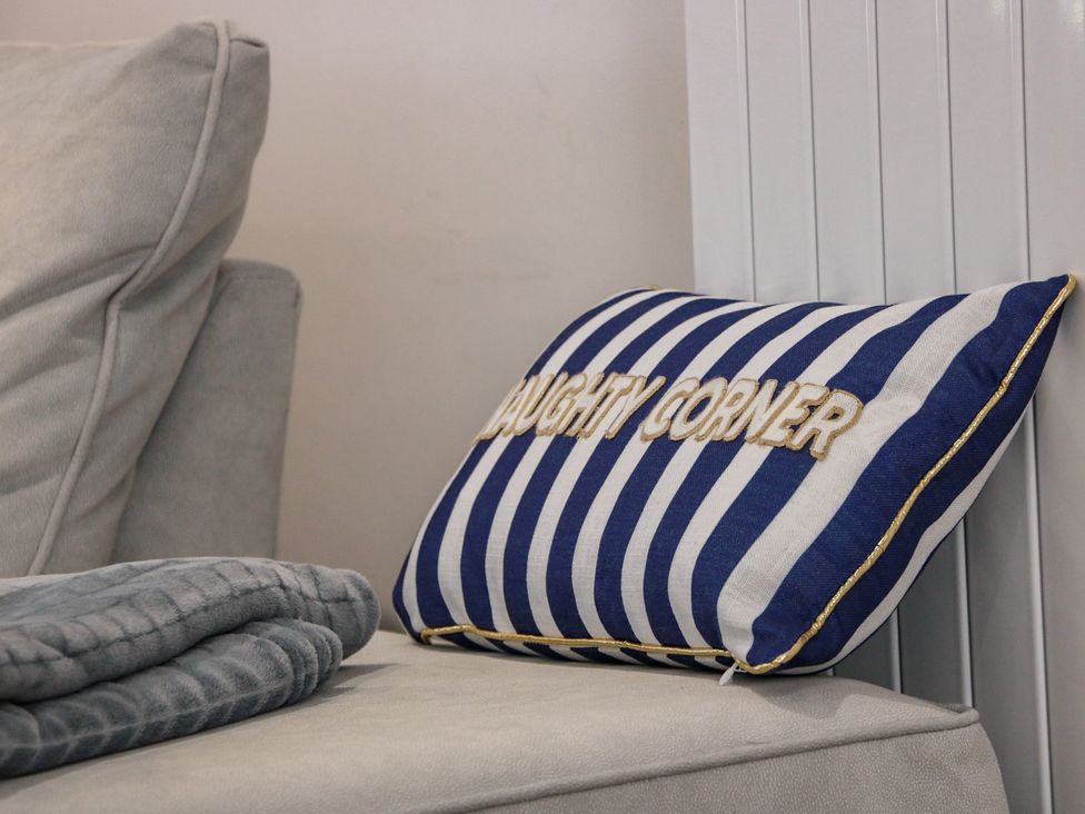 A living room with a striped cushion and blanket at Olea Portpatrick