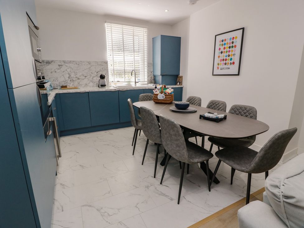 A kitchen with a dining table and chairs at Olea in Portpatrick