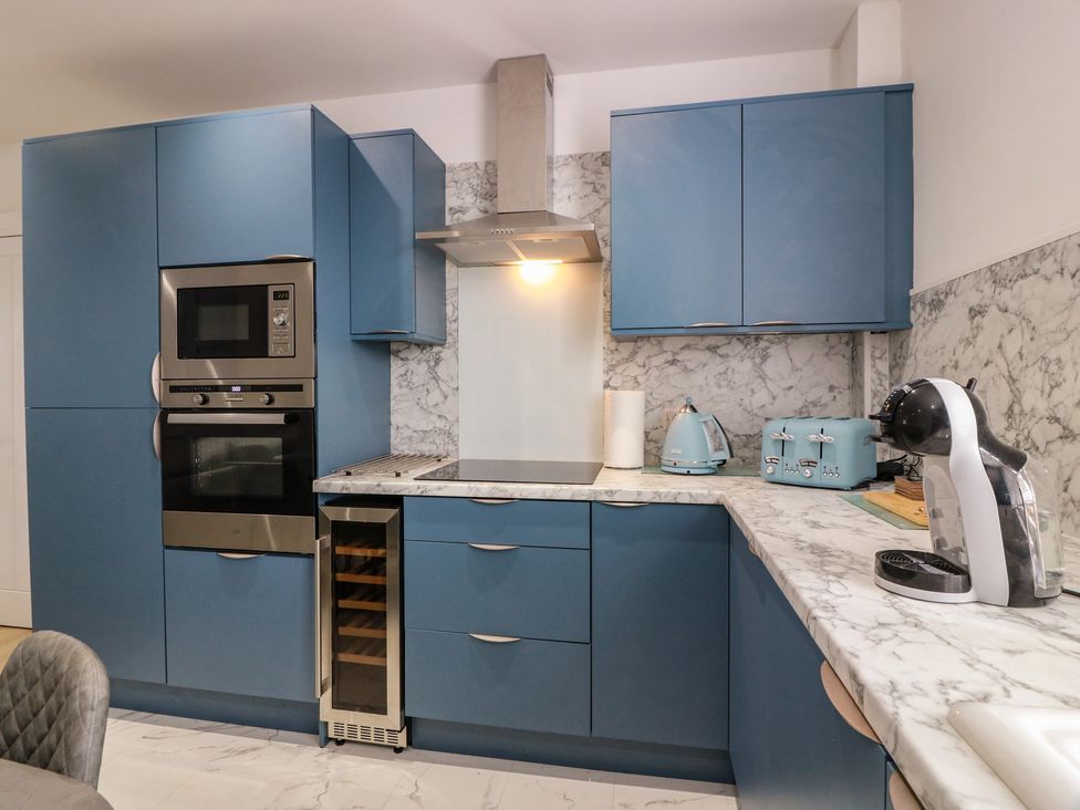 A kitchen with blue cabinets and appliances at Olea Portpatrick