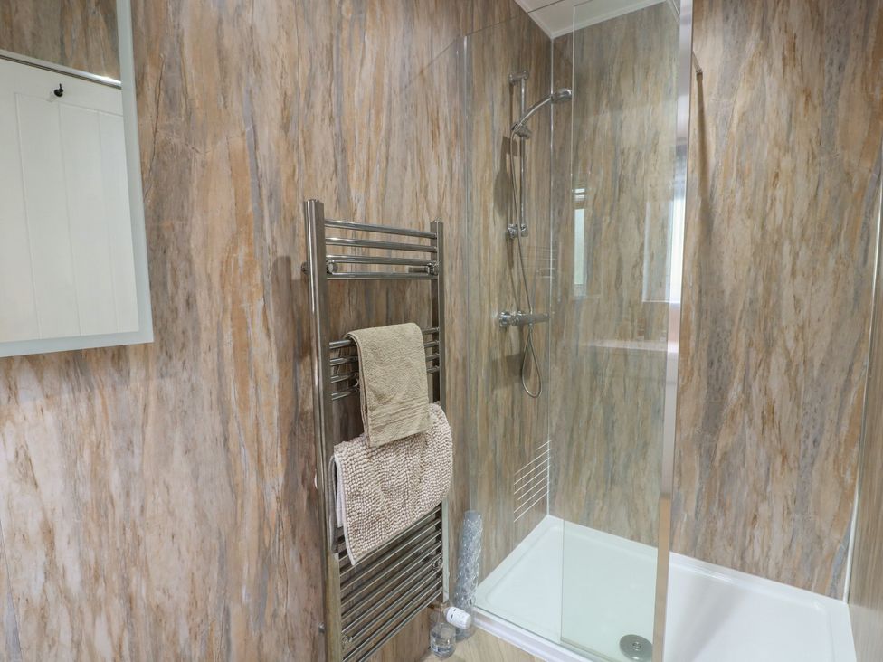 A bathroom with a shower and towel radiator at Olea in Portpatrick