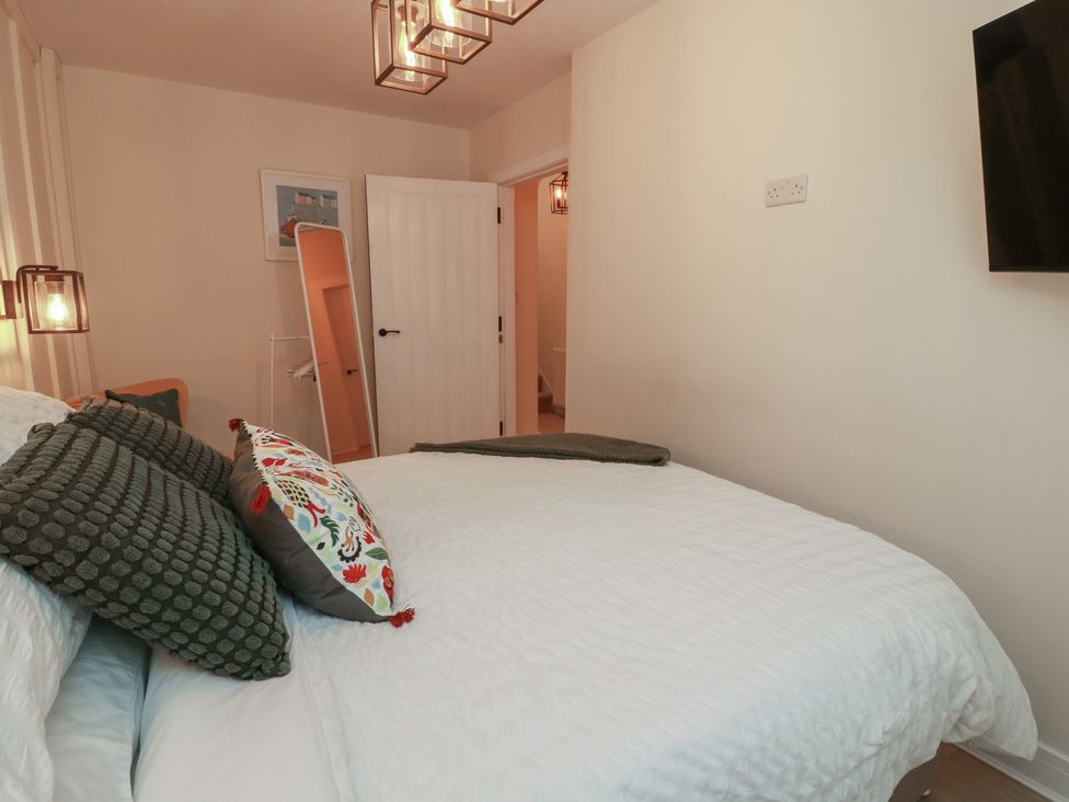 A bedroom with a bed and a mirror at Olea in Portpatrick