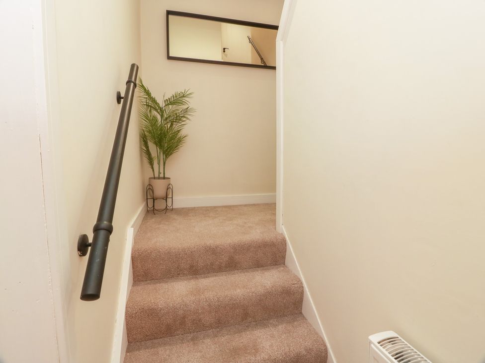 A stairway with a handrail and plant at Olea Portpatrick