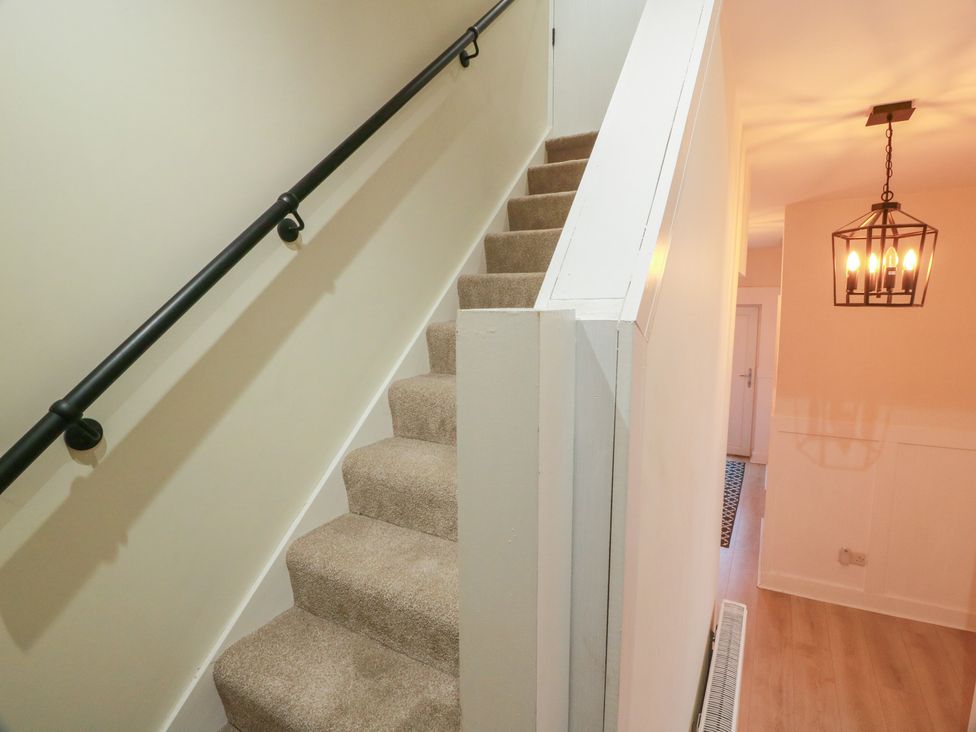 A staircase and hallway with a light fixture at Olea in Portpatrick