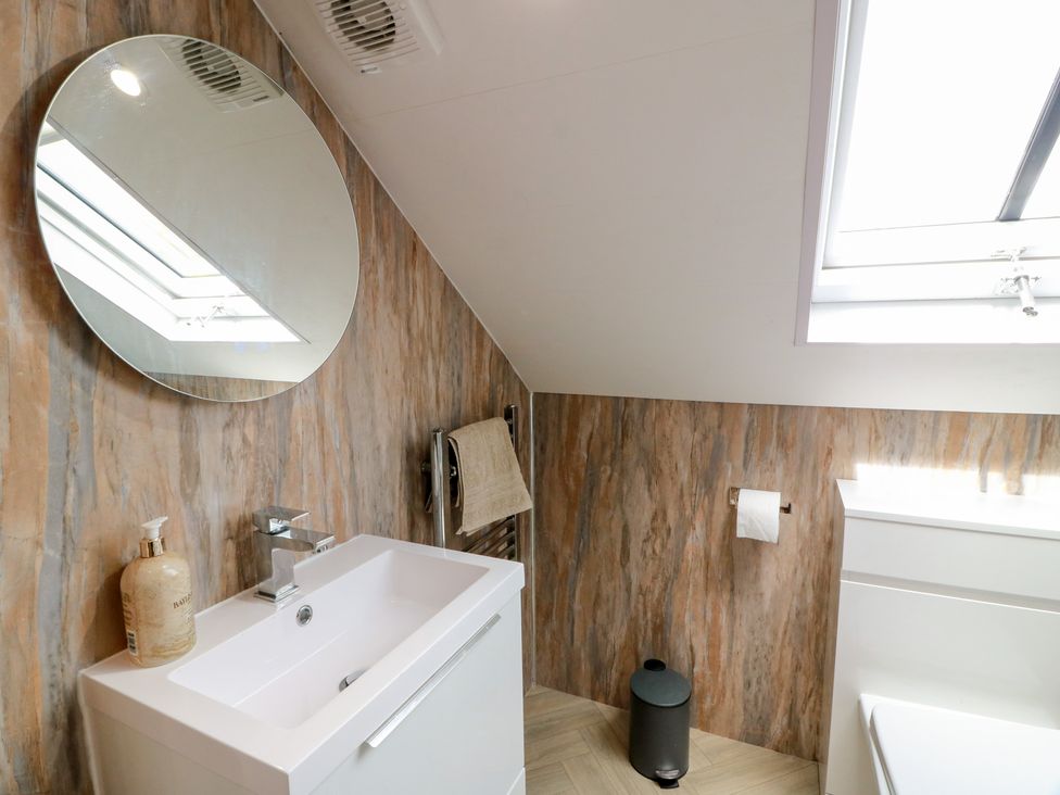 A bathroom with a sink and mirror at Olea in Portpatrick