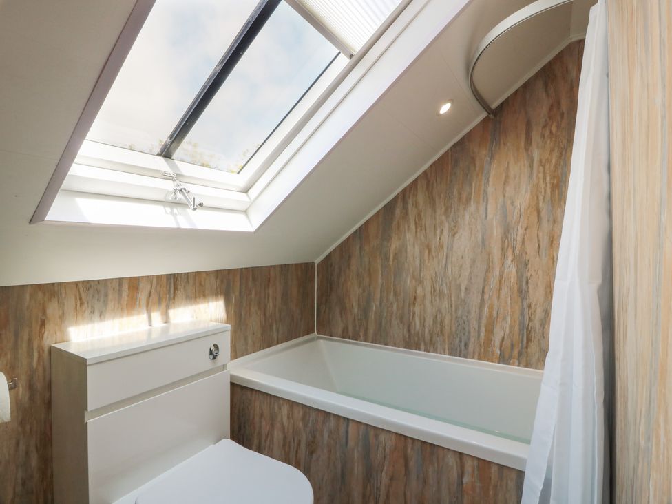 A bathroom with a bath tub and toilet at Olea in Portpatrick