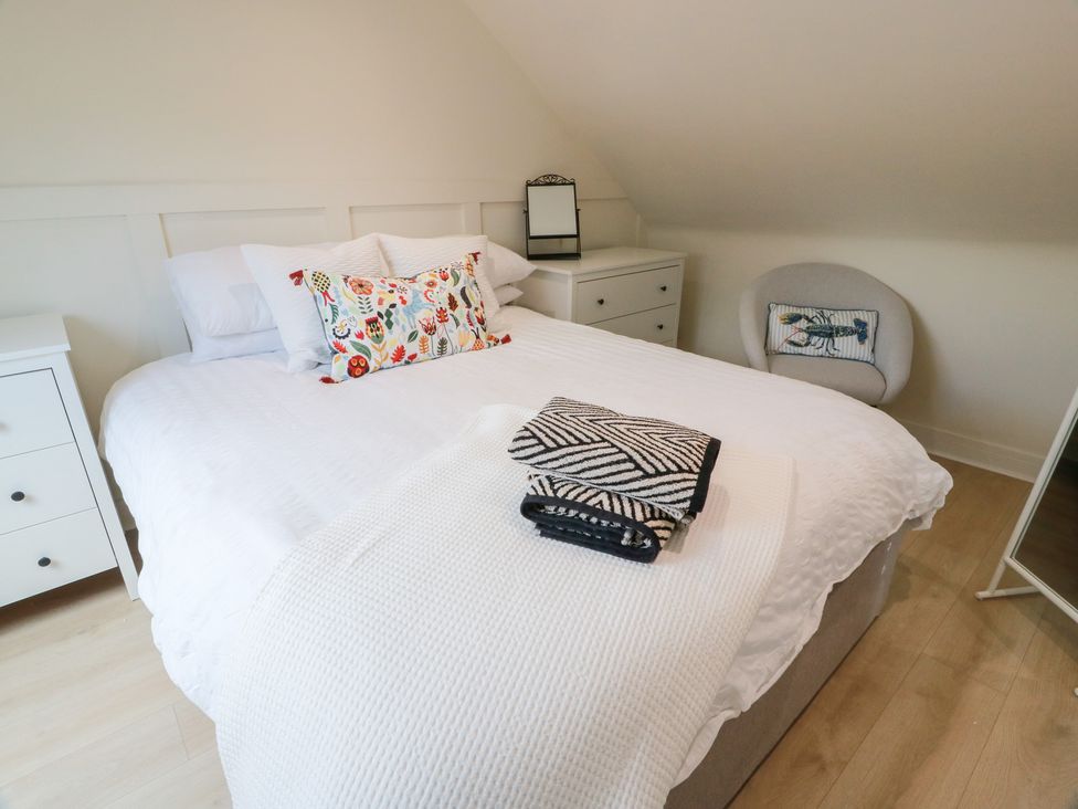 A bedroom with a bed and armchair at Olea Portpatrick