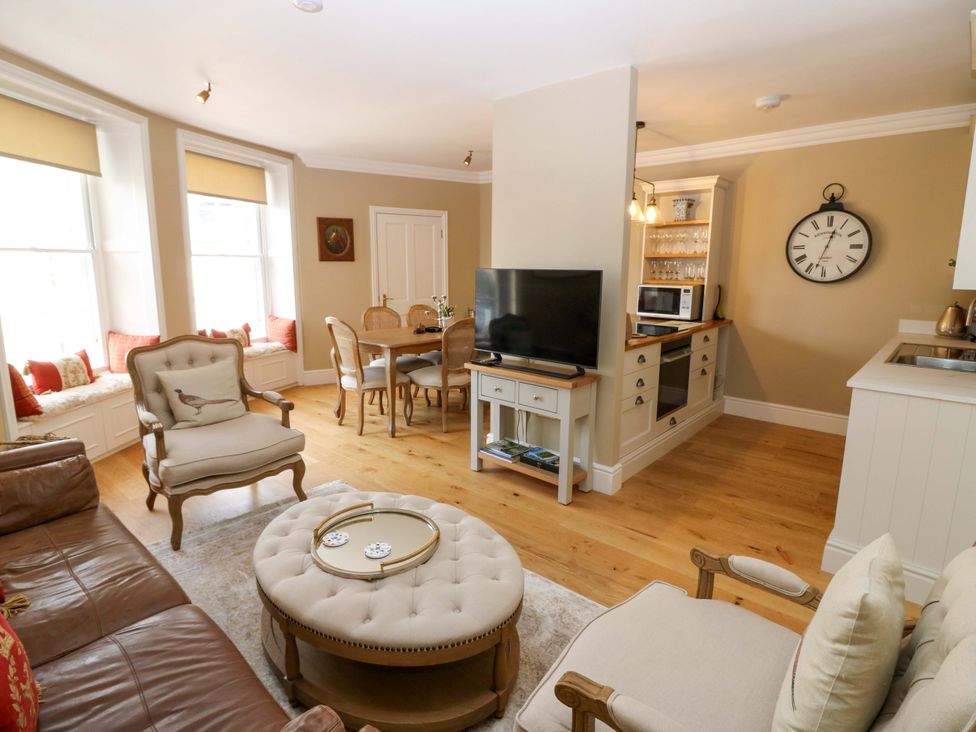 A living room with a dining area and kitchen at Woodmarket Apartments in Kelso
