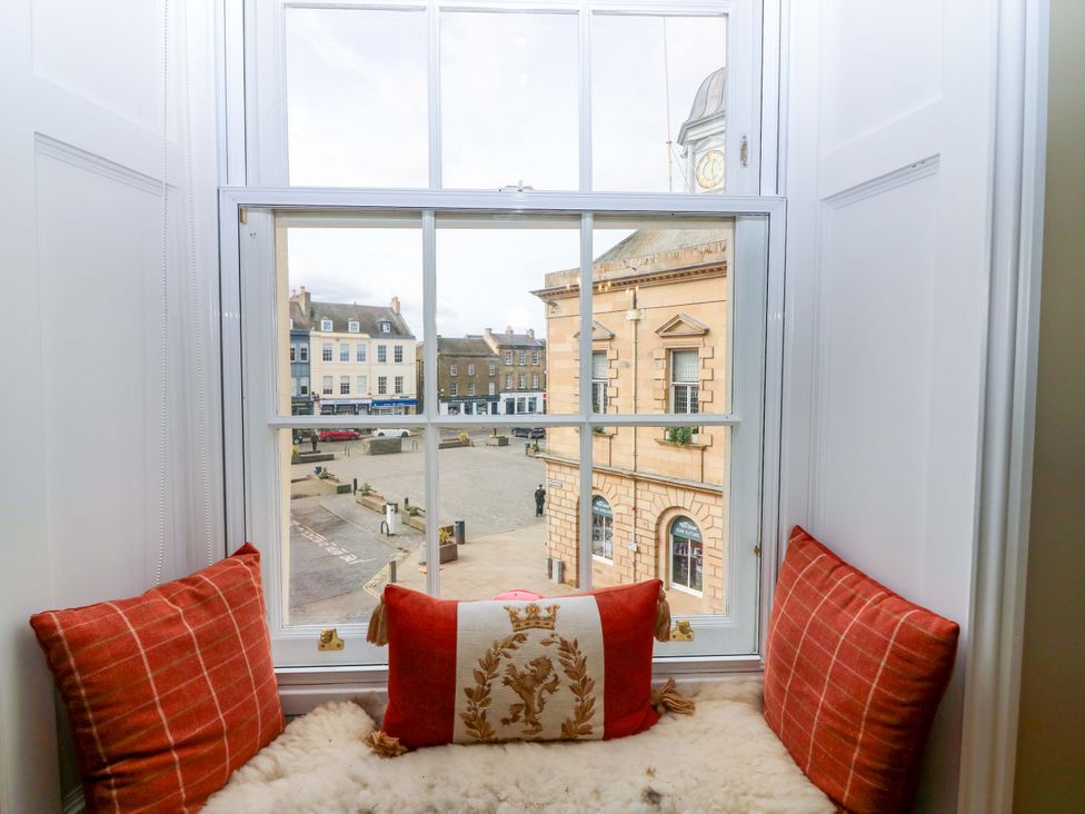 A window with cushions overlooking a plaza at Woodmarket Apartments in Kelso