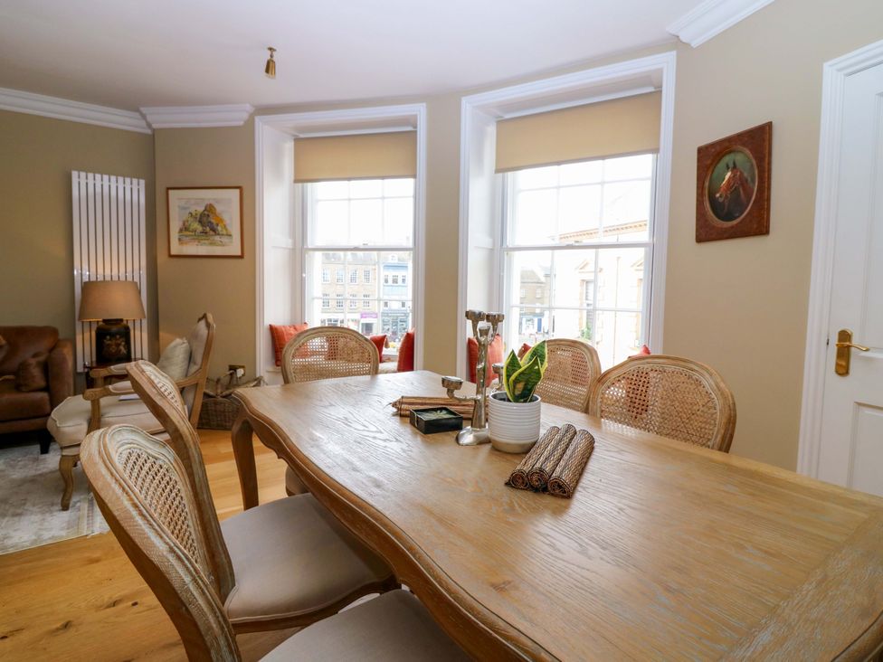 A dining room with a large table and chairs at Woodmarket Apartments in Kelso