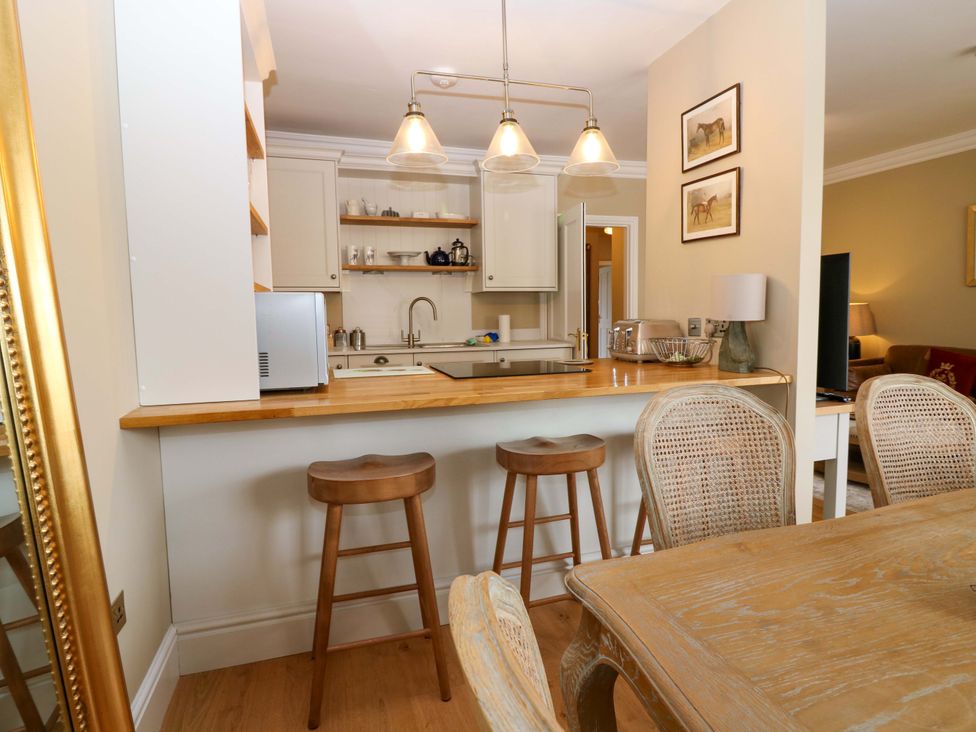 A kitchen with bar stools and kitchen appliances at Woodmarket Apartments in Kelso