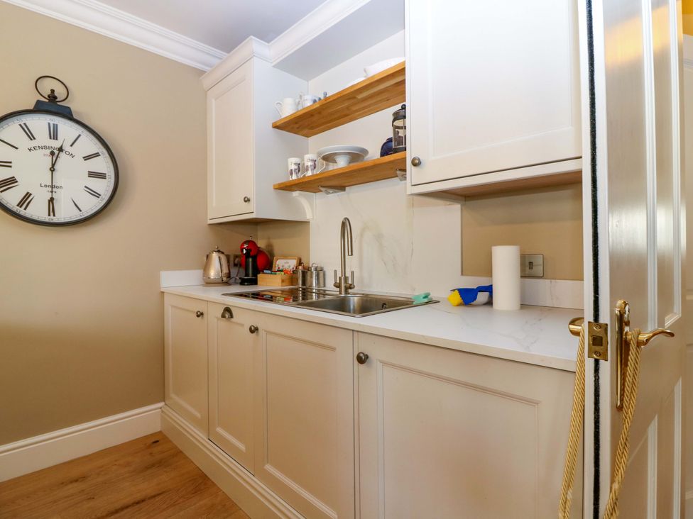 A kitchen with cabinets and a sink at Woodmarket Apartments in Kelso