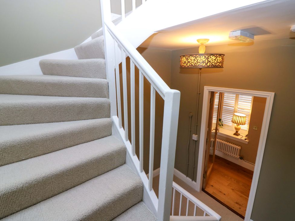 A staircase with a door and light fixture in Woodmarket Apartments, Kelso