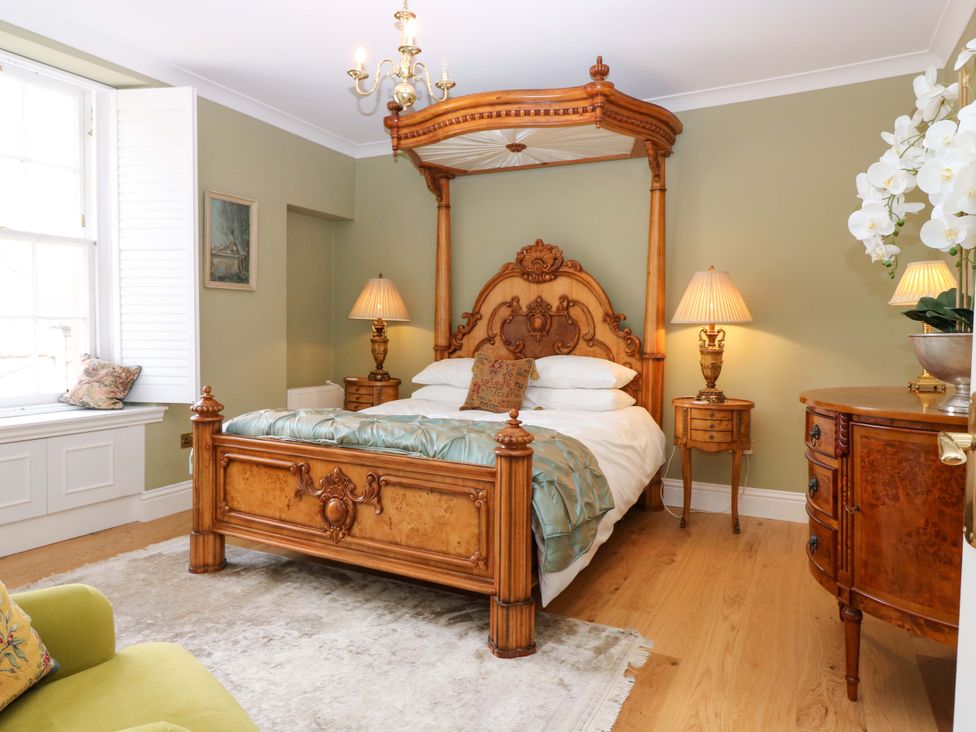 A bedroom with a four-poster bed and lamps at Woodmarket Apartments in Kelso