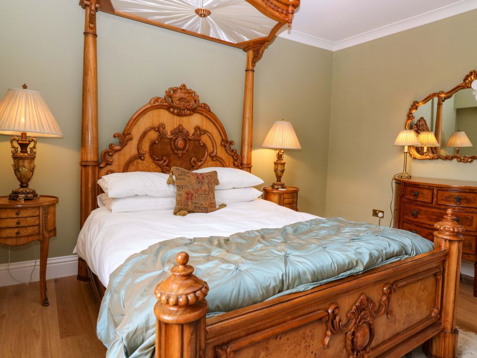 A bedroom with a wooden bed and nightstands at Woodmarket Apartments, Kelso