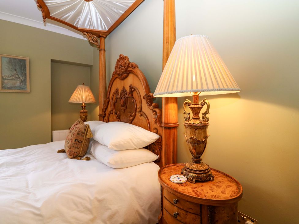 A bedroom with a bed and bedside table at Woodmarket Apartments in Kelso