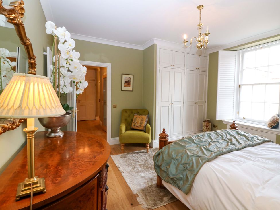 A bedroom with a bed and wardrobe at Woodmarket Apartments in Kelso