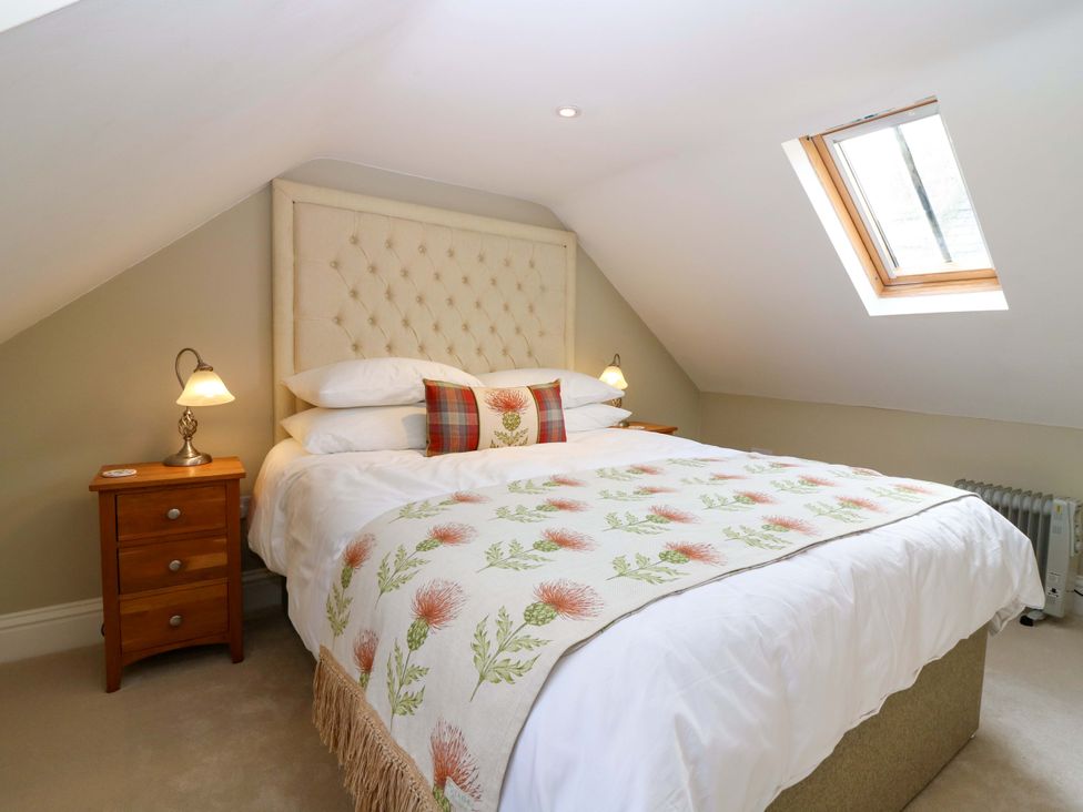 A bedroom with a bed and nightstand at Woodmarket Apartments in Kelso