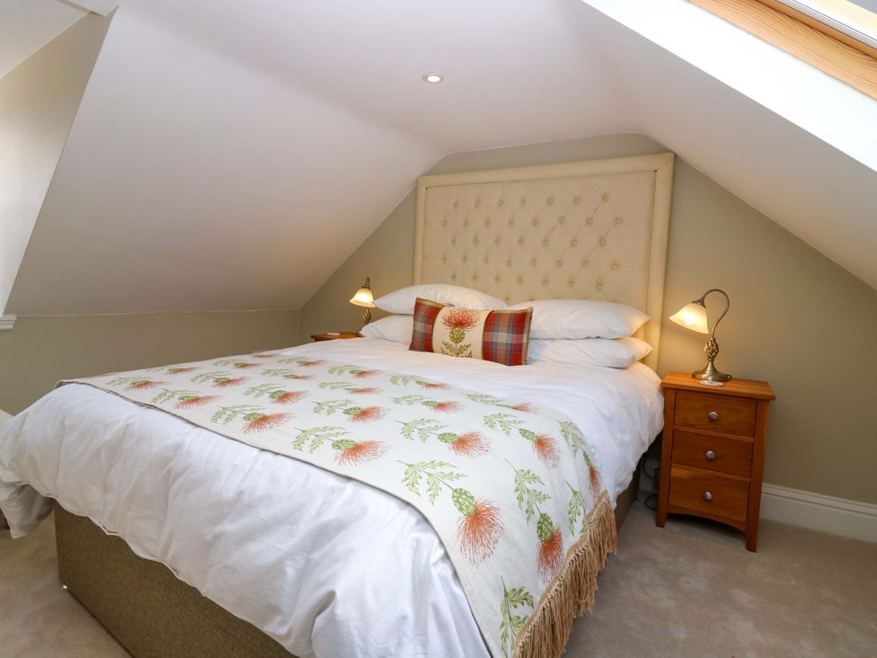 A bedroom with a bed and bedside table at Woodmarket Apartments in Kelso