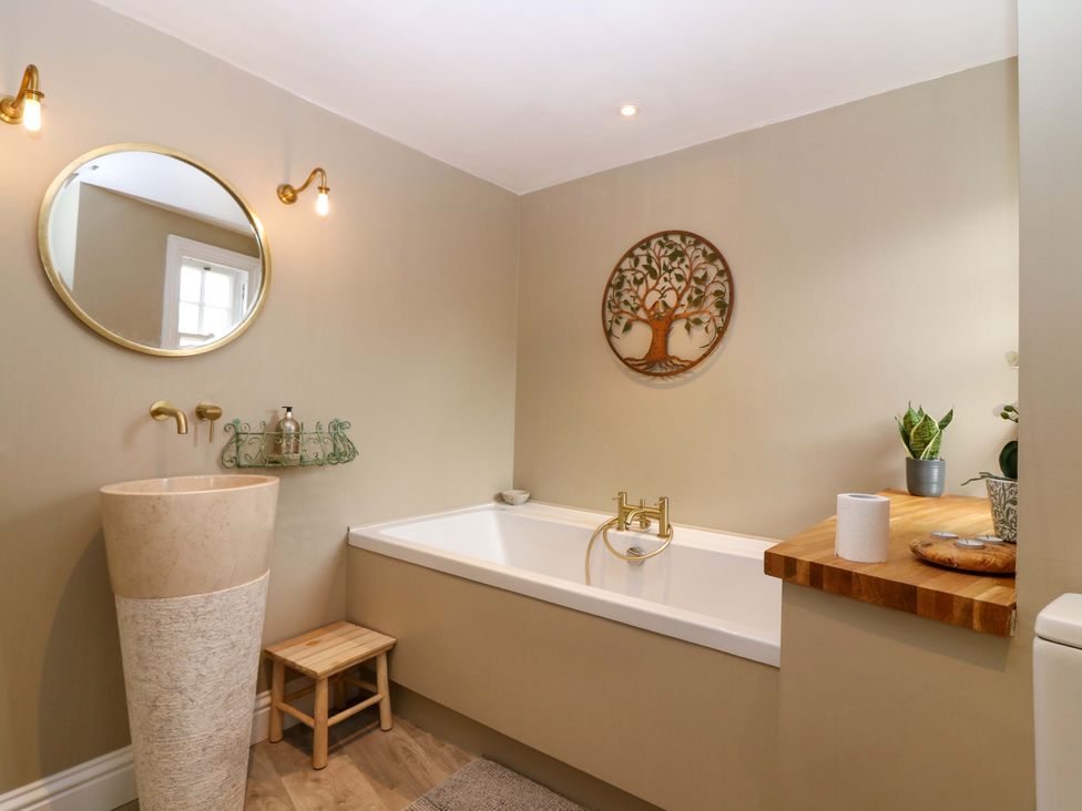 A bathroom with a bathtub and a plant at Woodmarket Apartments in Kelso
