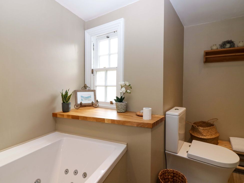 A bathroom with a bathtub and toilet at Woodmarket Apartments in Kelso