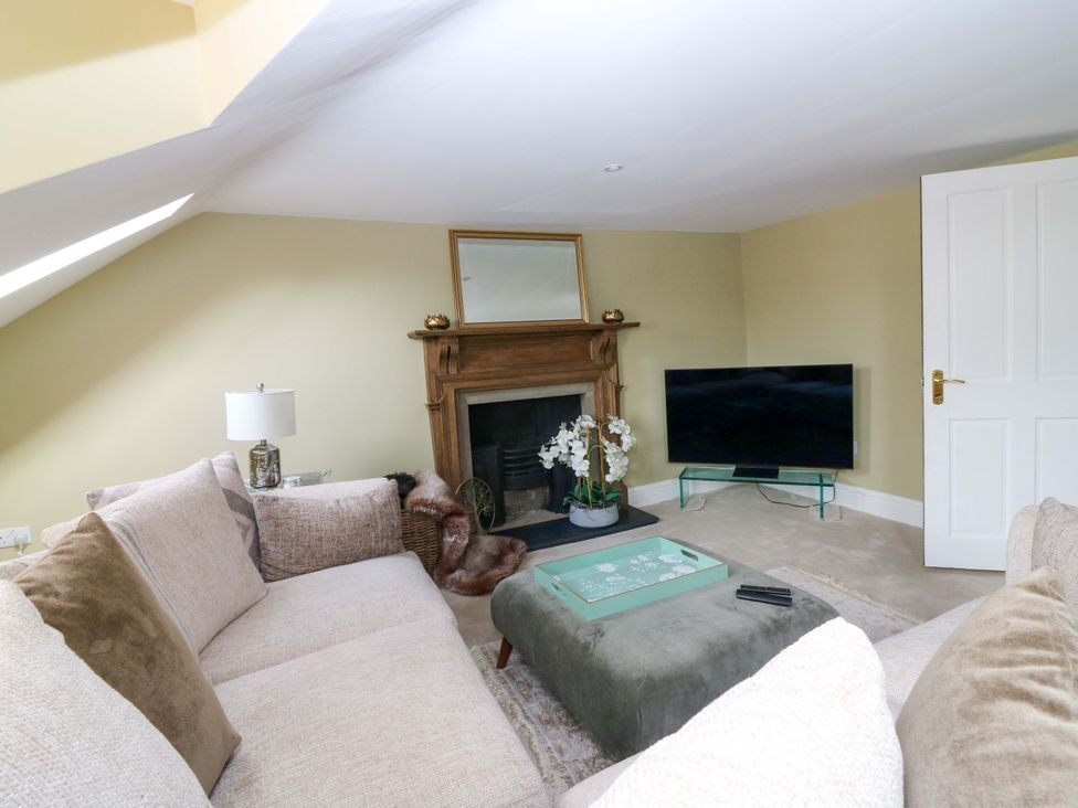 A living room with a sofa and television at Woodmarket Apartments in Kelso