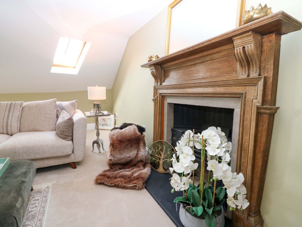 A living room with a fireplace and sofa at Woodmarket Apartments in Kelso