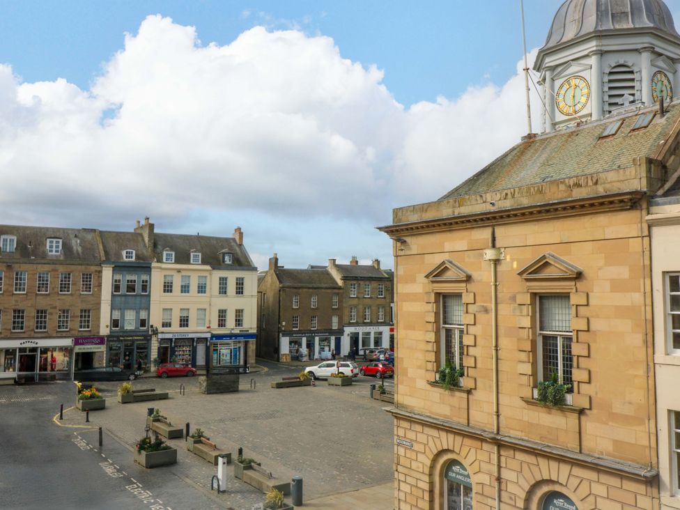 A view of a square with buildings and a clock tower at Woodmarket Apartments in Kelso