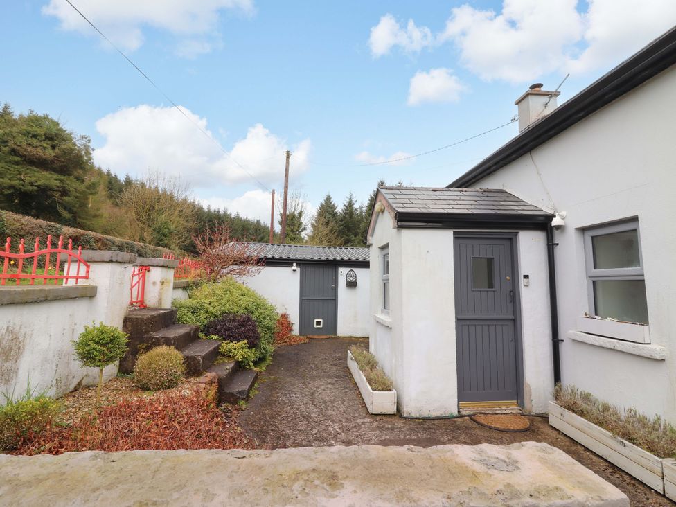 An outdoor view of a house with a garden and shed at Turraheen in Cashel