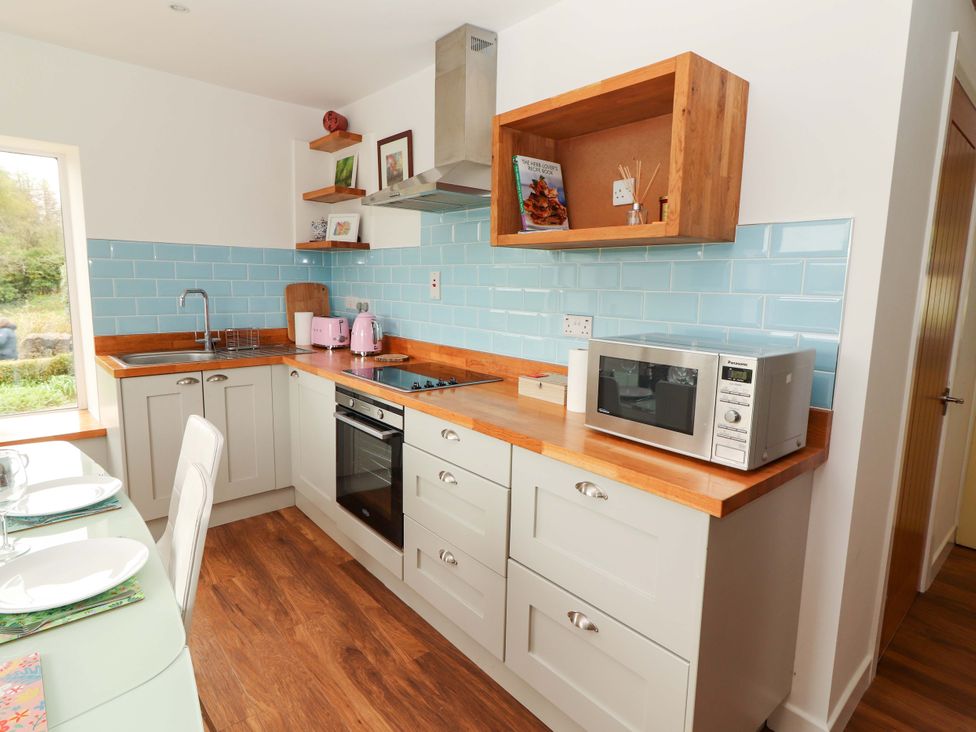 A kitchen with a sink, stove, and microwave at Turraheen in Cashel