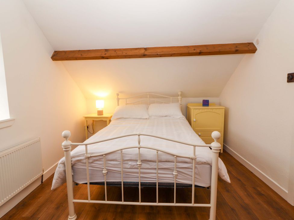 A bedroom with a bed and yellow dresser at Turraheen in Cashel